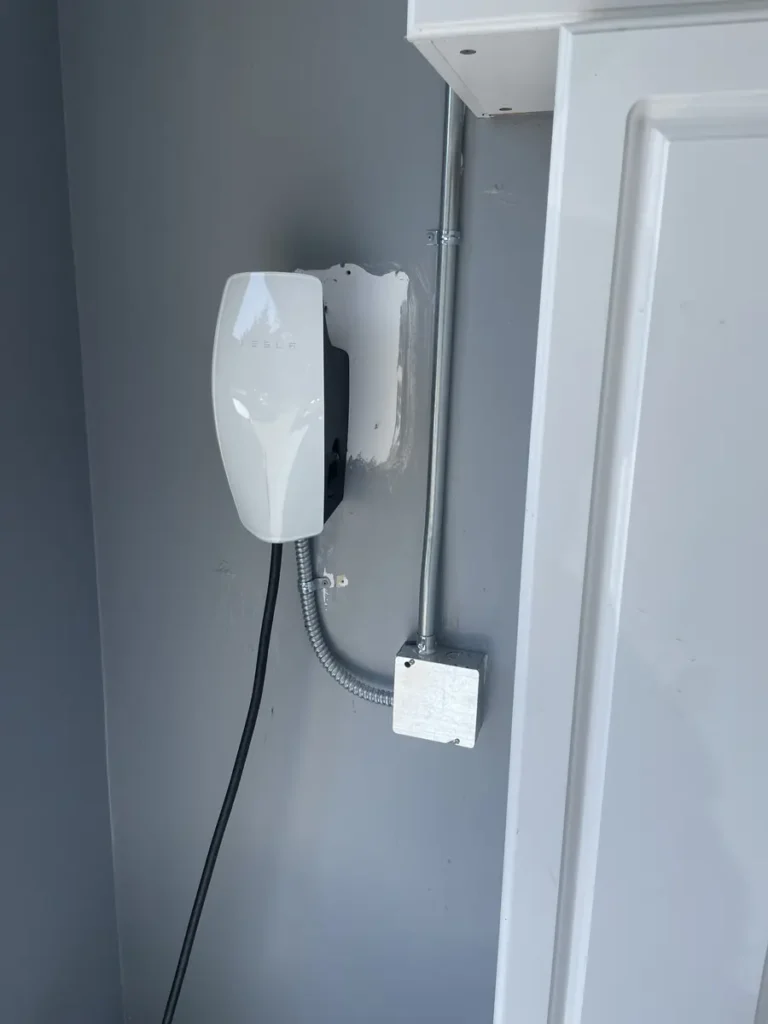 Wall-mounted Tesla EV charger with conduit